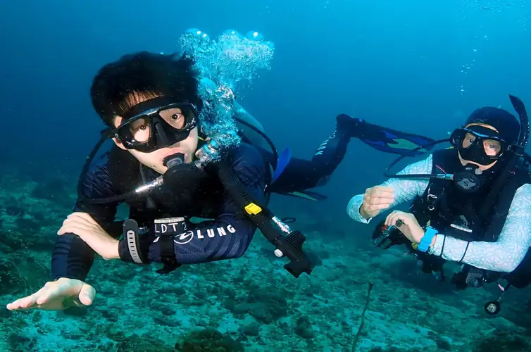 A pair of SCUBA divers, an instructor and a student  learning underwater navigation
