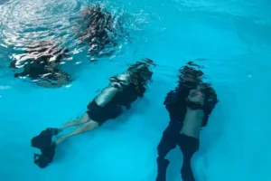 SCUBA divers submerged in a training pool