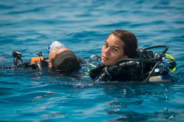 Two female SCUBA divers at the surface practice diver tow during a rescue course.